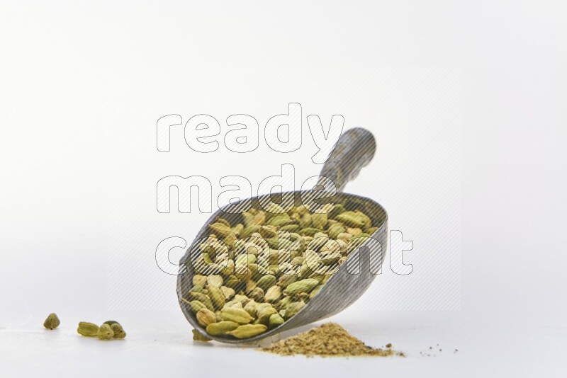 Cardamon in a shovel on white background