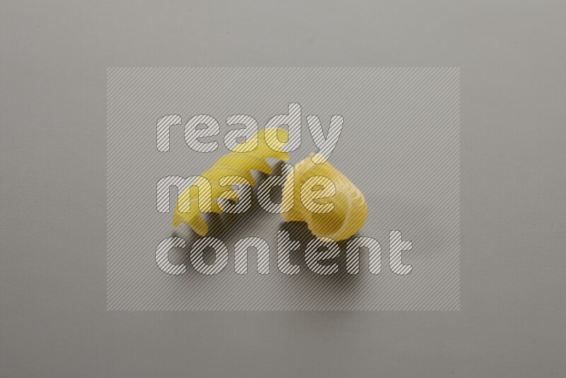 Pipe pasta with other types of pasta on grey background