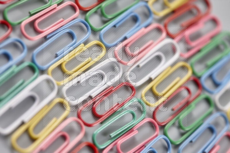 Multicolored paper clips isolated on a grey background