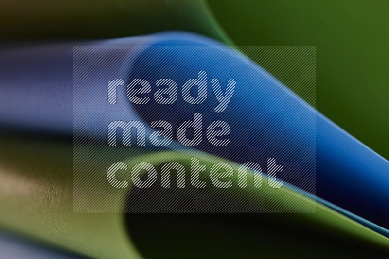 An abstract art showing blue and green paper sheets arranged in an overlapping curves