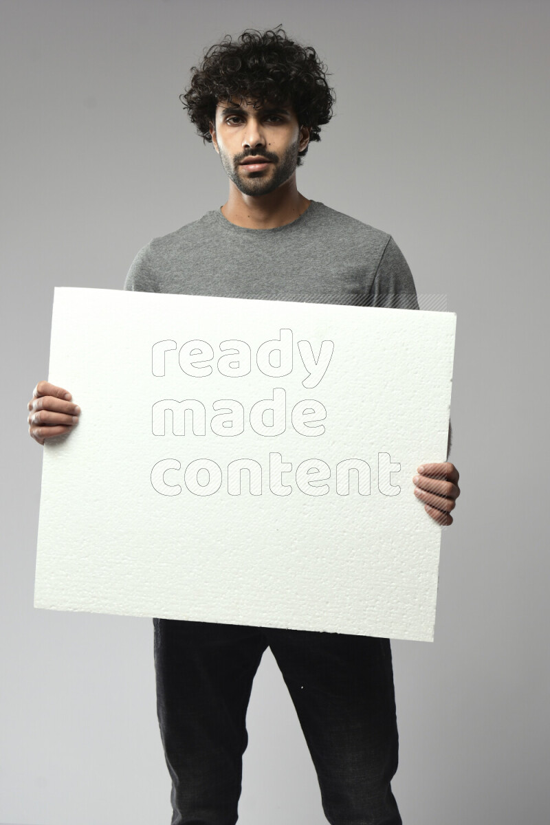A man wearing casual standing and holding a white board on white background