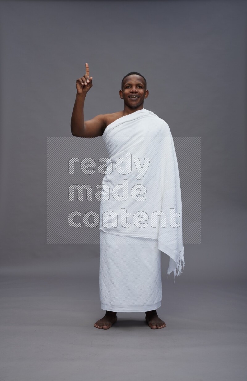 A man wearing Ehram Standing Interacting with the camera on gray background