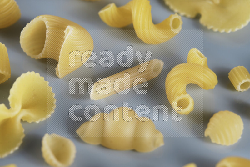 Different pasta types on light blue background