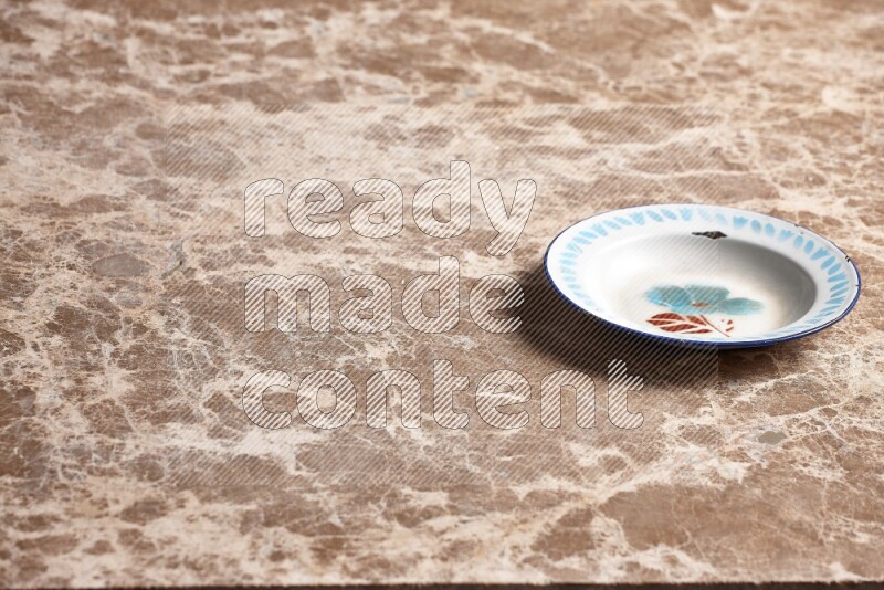 A vintage metal plate on beige marble background