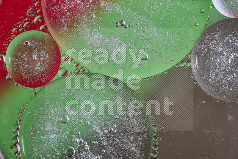 لقطات مقربة لفقاعات من الزيت على سطح الماء باللون البني والأخضر والأحمر