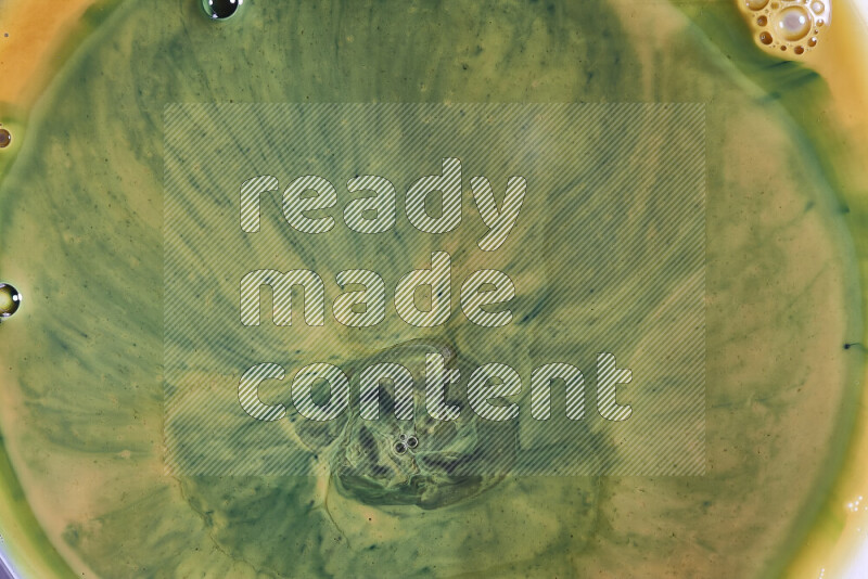 A close-up of abstract swirling patterns in orange and green