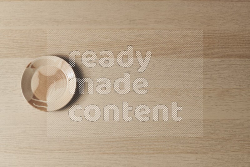 صحن فخاري متعدد الألوان على خلفية خشبية فاتحة