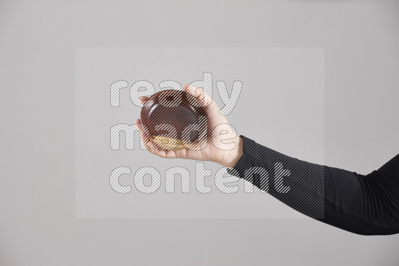 امرأة ترتدي عباءة سوداء تحمل أدوات خشبية مختلفة في أوضاع متعددة