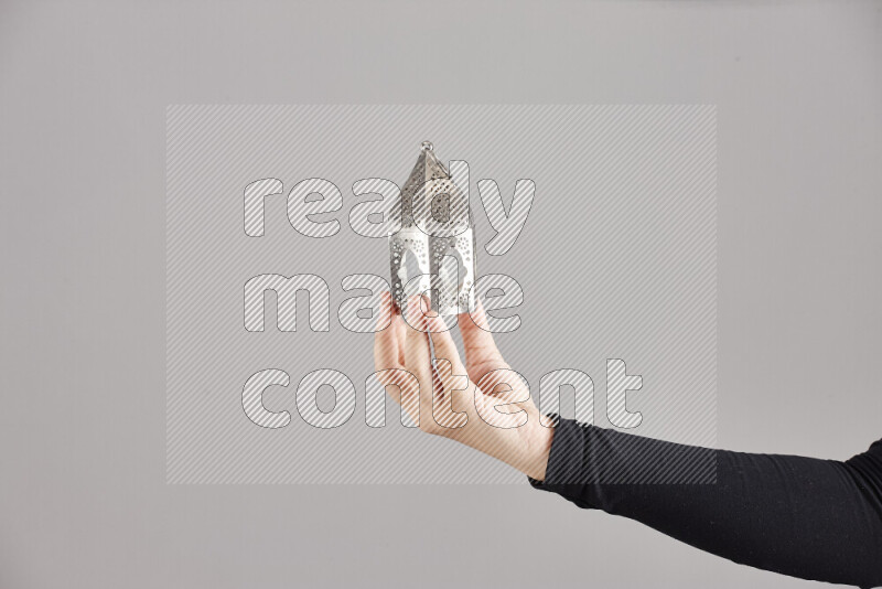 A woman in black abaya holding different ramadan lanterns in different positions