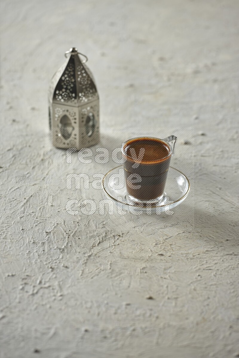 A silver lantern with different drinks, dates, nuts, prayer beads and quran on textured white background