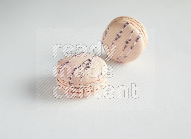 45º Shot of two pink orange blossom macarons on white background