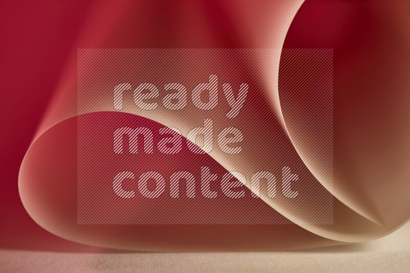 An abstract art piece displaying smooth curves in gold and red gradients created by colored light