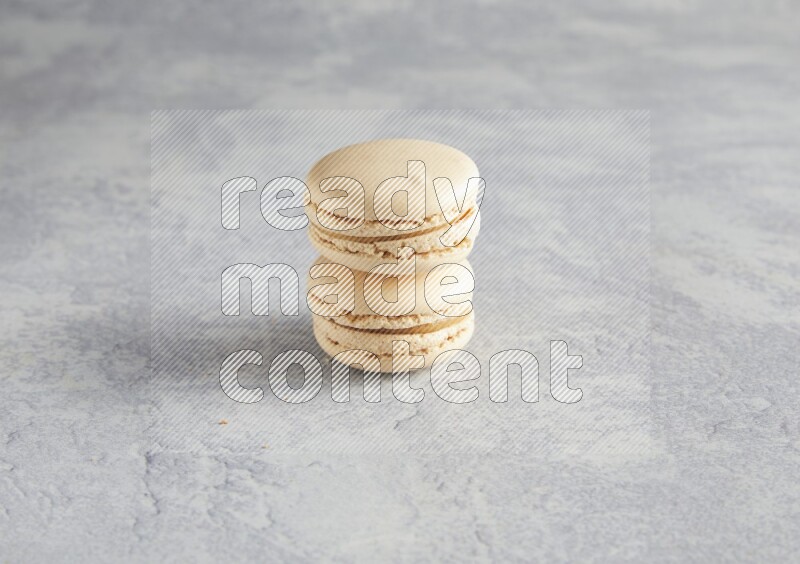 45º Shot of two white marbleCaramel fleur de sel macarons  on white  marble background