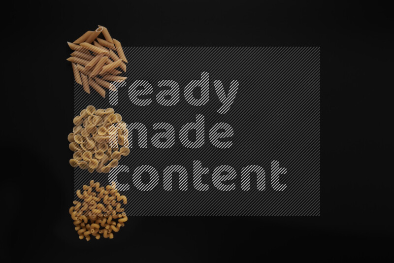 Different pasta types in 3 bunches on black background