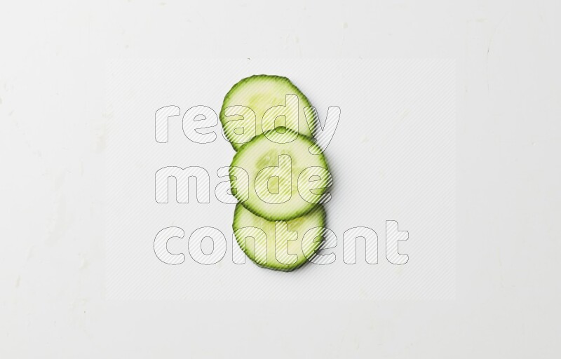 three cucumber slices on white background