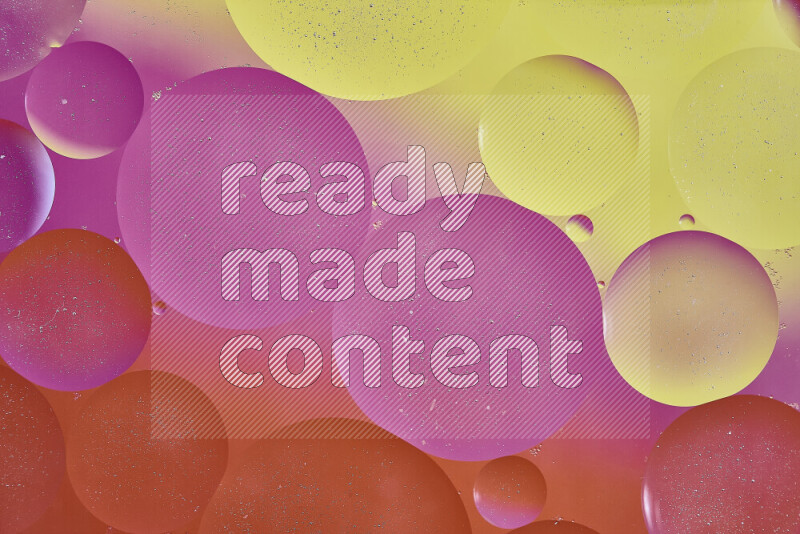 Close-ups of abstract oil bubbles on water surface in shades of yellow, orange and pink