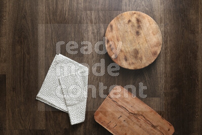 Wooden (chopping boards, spoon, salt and pepper pinch pot), juice jar and a napkin on wooden background