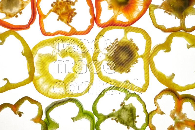 Mixed vegetables and fruits slices on illuminated white background