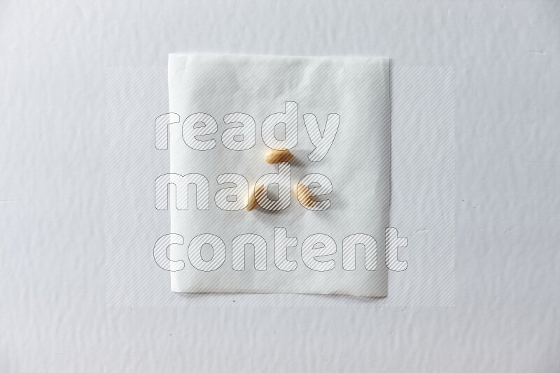 3 peeled peanuts on a piece of paper on a white background in different angles