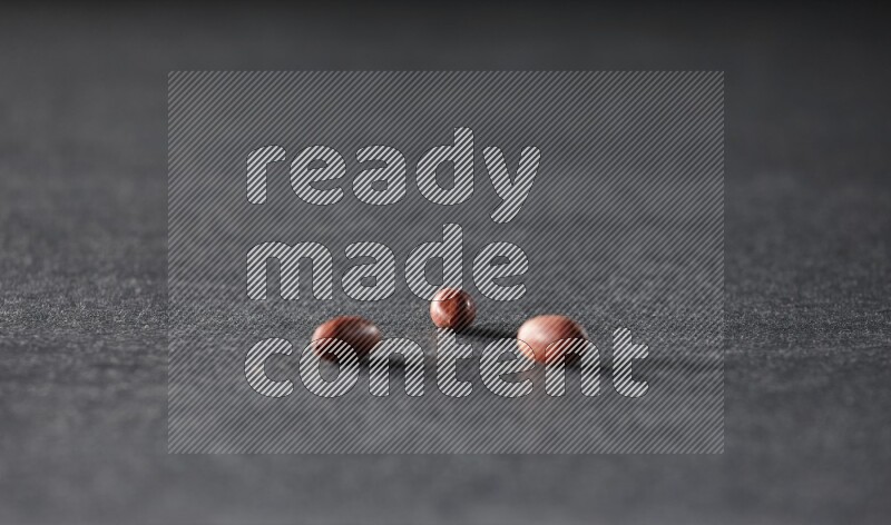 3 red skin peanuts on a black background in different angles