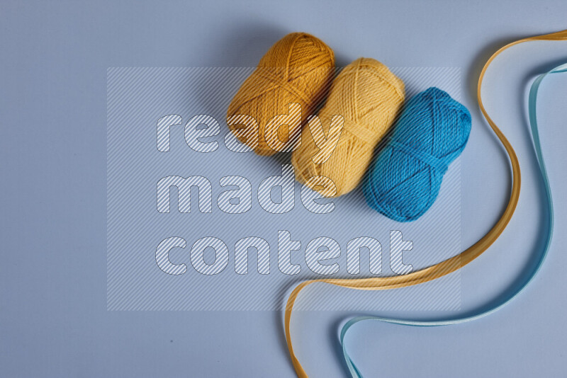 مجموعة من أدوات الخياطة والتفصيل صفراء وزرقاء اللون على خلفية زرقاء