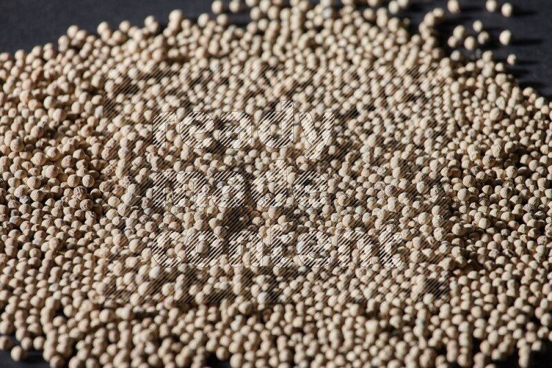 White pepper beads on black flooring