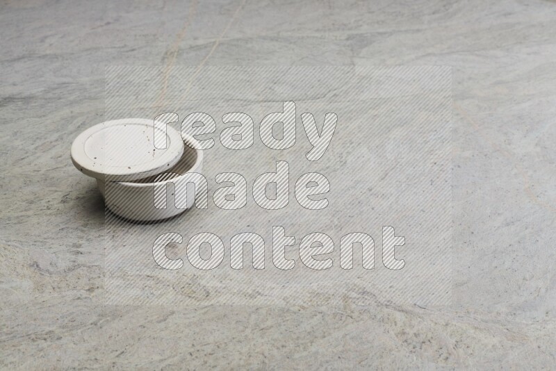 A white pottery bowl on grey marble background