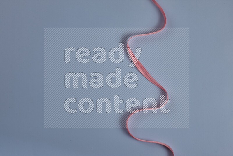 A pink collection of sewing and tailoring tools arranged on a blue background