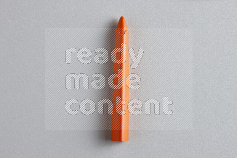 A close-up showing a single wax crayon on grey background