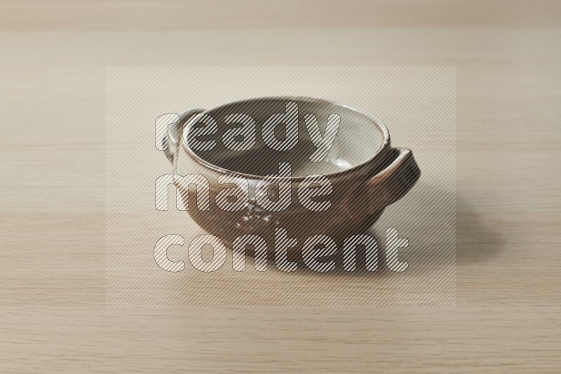 A multicolored pottery bowl on light wooden background