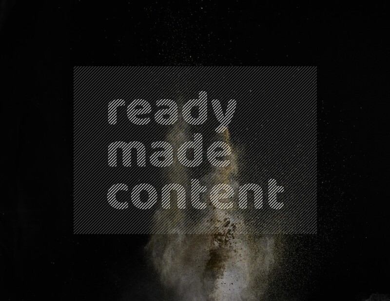 A side view of brown powder explosion on black background