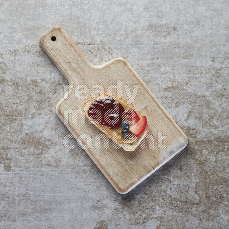 open faced peanut butter sandwich with jam, strawberries and blueberries & chia on a  grey textured background