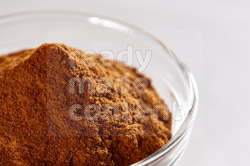 A glass bowl full of ground paprika powder on white background