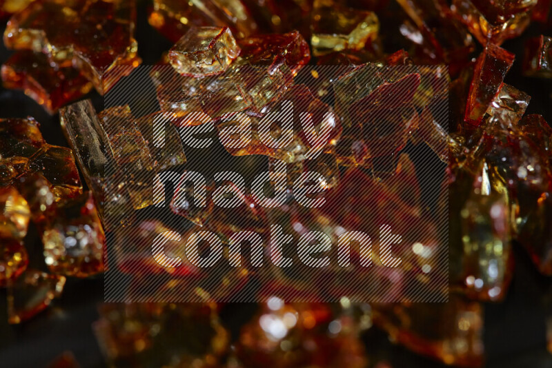 قطع زجاج برتقالية شفافة متناثرة على خلفية سوداء