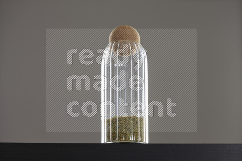 Freekeh in a glass jar on black background