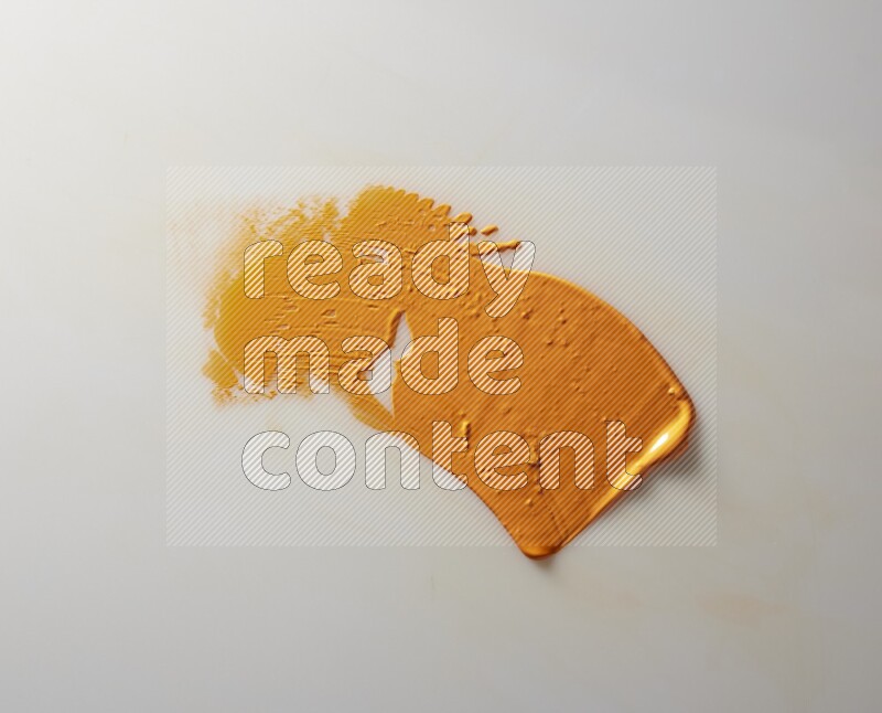 An orange single curved painting knife stroke on white background