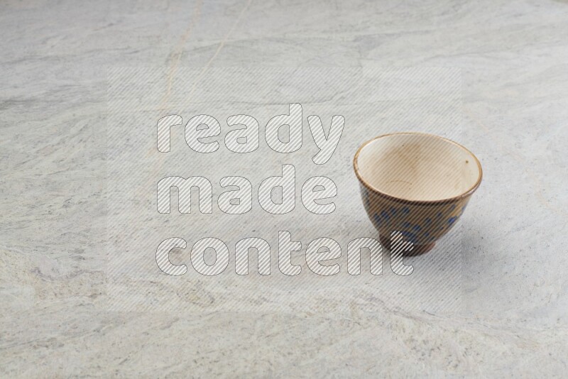 A multicolored pottery bowl on grey marble background