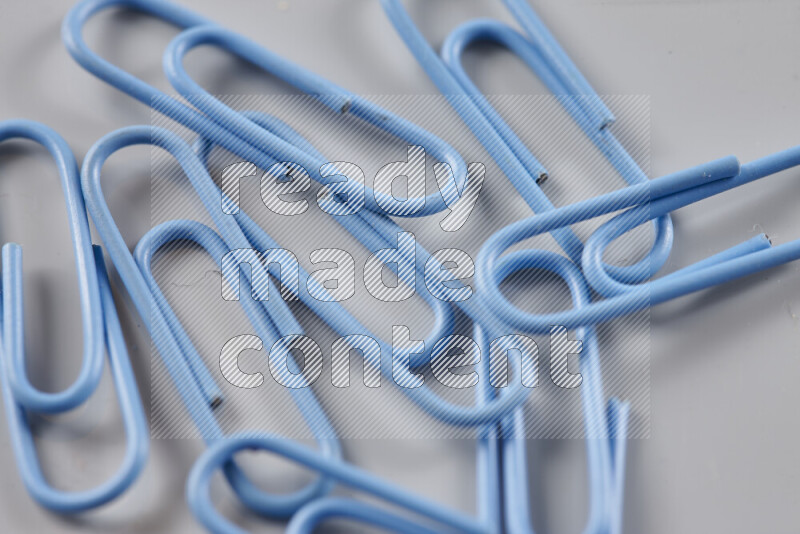 Blue paper clips isolated on a grey background