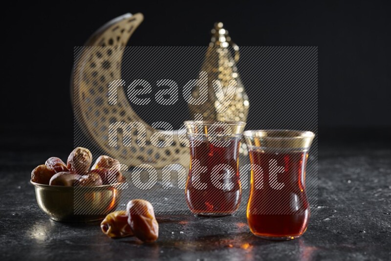 تمر مع مشروبات ساخنة وفوانيس ذهبية علي خلفية سوداء خشبية