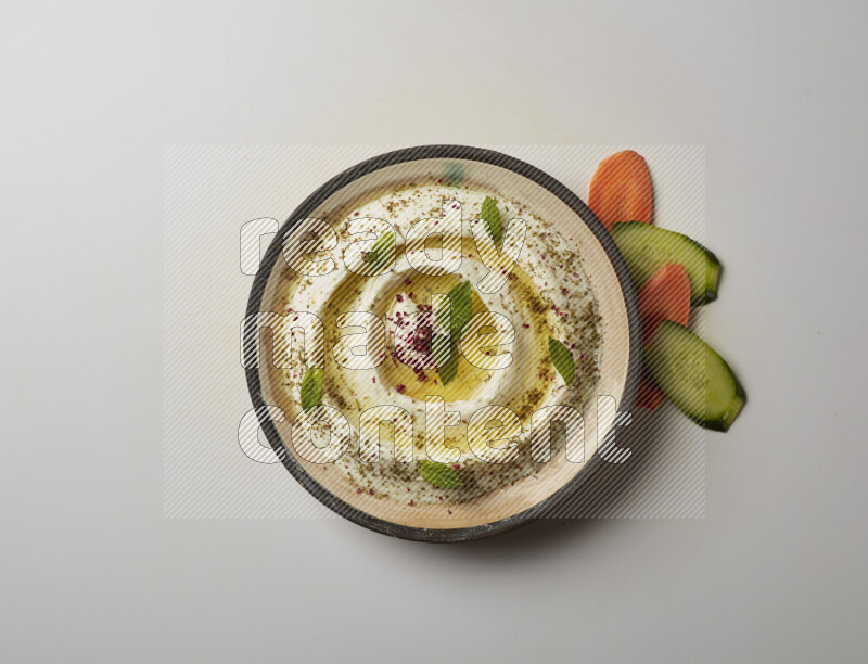 Lebnah garnished with zaater, mint & sumak in a pottery plate on a white background