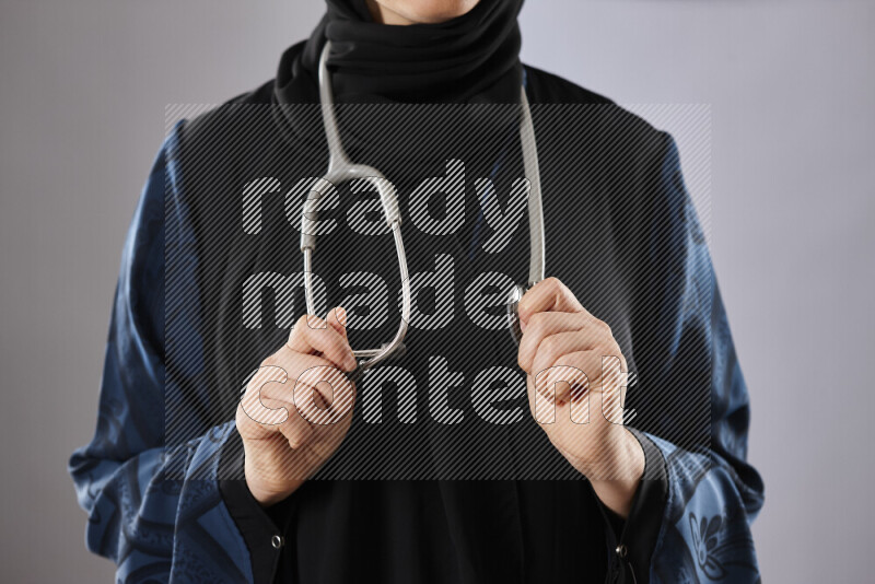 Female doctor wearing an abaya and medical attire in different positions