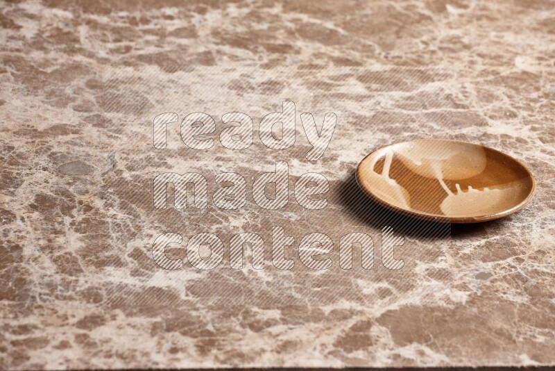 A multicolored pottery plate on beige marble background