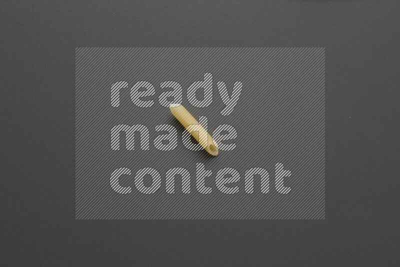 Mini penne pasta on grey background