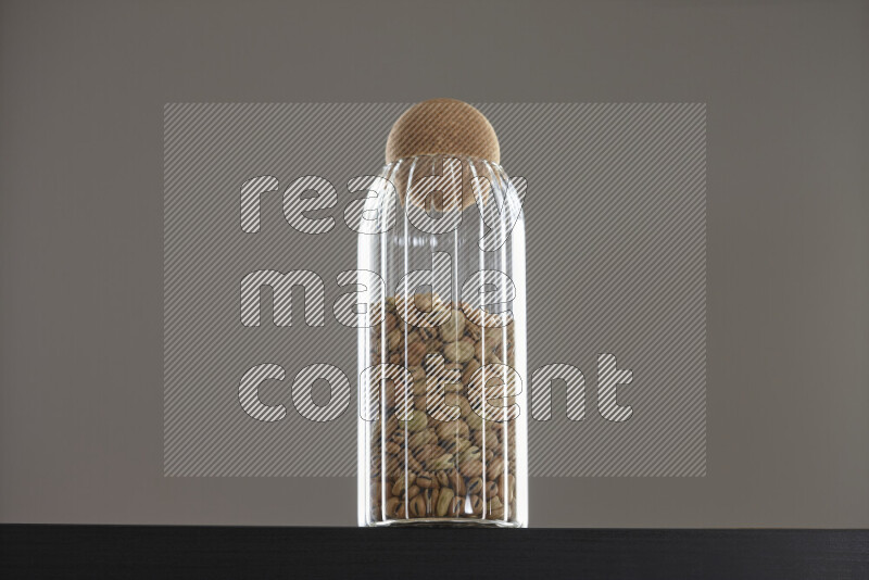 Fava beans in a glass jar on black background