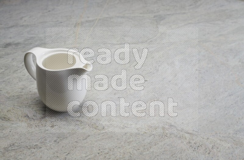A ceramic milk jug on grey marble background