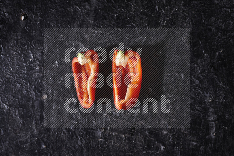 Red bell pepper slices on black background