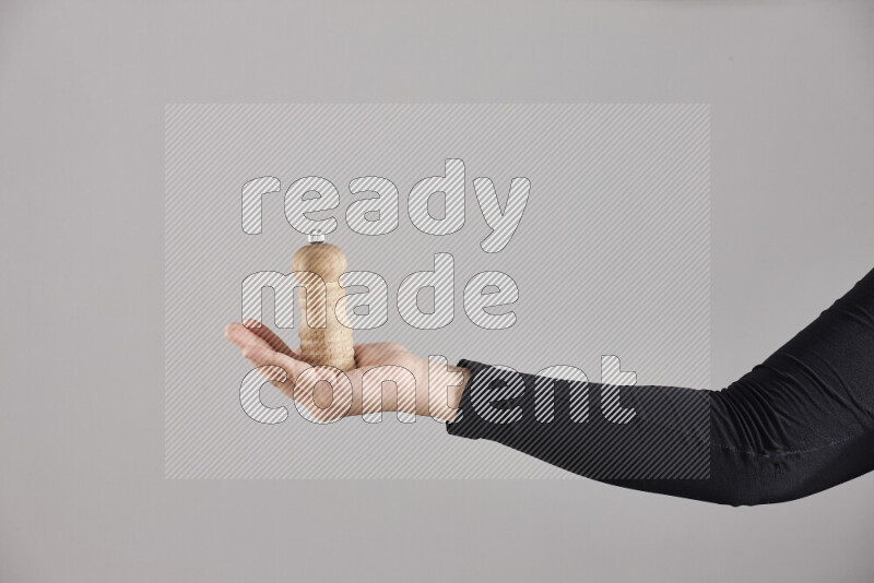 A woman in black abaya holding different wooden essentials in different positions