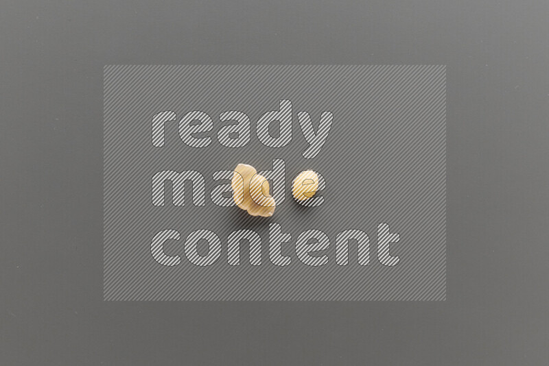 Snails pasta with other types of pasta on grey background