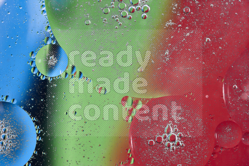Close-ups of abstract oil bubbles on water surface in shades of red, green and blue