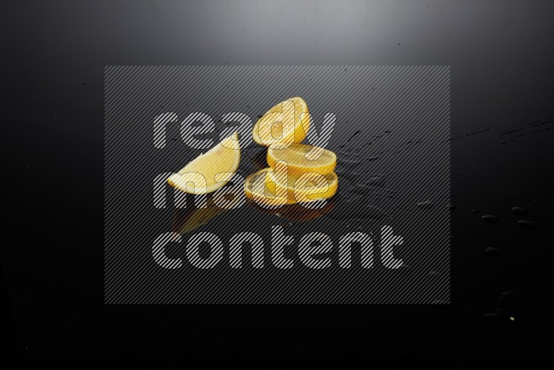 Lemon slices with water drops, and droplets on black background